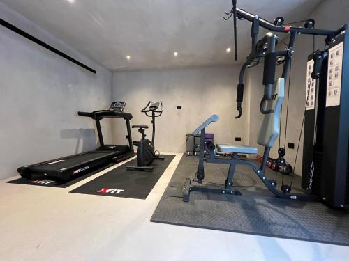 a gym with two treadmills and two exercise bikes at Lithos Art Villas in Sarlata