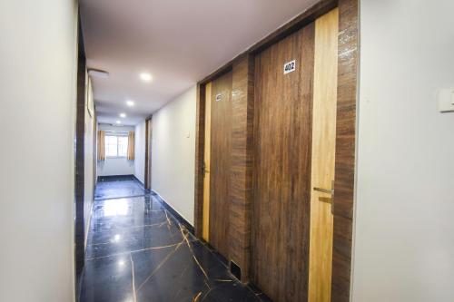 a hallway with wood paneled walls and a hallway with a hallway at Hotel O Mourigram Near Andul Rd in Kolkata