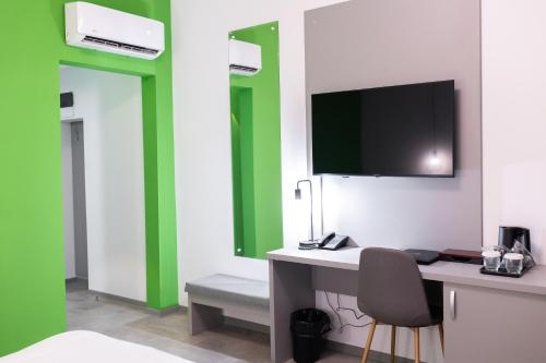 a room with a desk and a tv on the wall at Johann Strauss Hotel in Bucharest