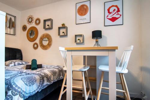 - une chambre avec un lit, une table et deux tabourets dans l'établissement Studio 