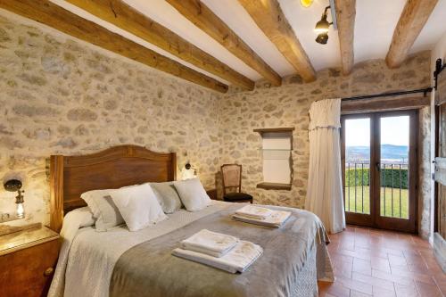 a bedroom with a bed in a room with stone walls at La Creu De La Pinya in Berga