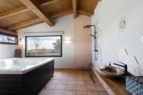 a bathroom with a large tub and a sink at La Creu De La Pinya in Berga