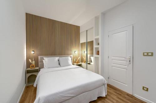 une chambre avec un lit blanc et un parquet dans l'établissement Appartement prestigieux à 5 minutes à pied de la gare et du palais de festival, à Cannes