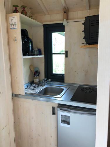 a kitchen with a sink and a stove at Les Lodges de Phanou in Prissac