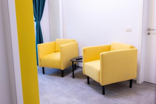 two yellow chairs and a table in a room at Johann Strauss Hotel in Bucharest