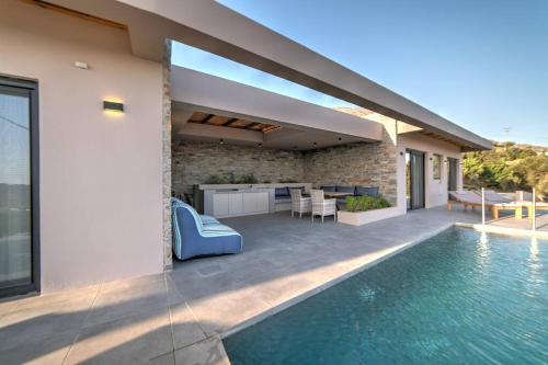 a house with a swimming pool next to a house at Villa Oniriko in Marioú