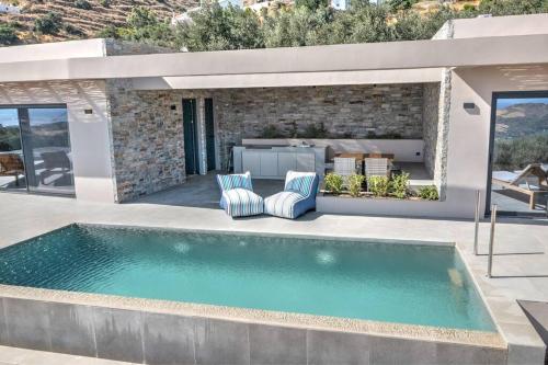 a swimming pool in the backyard of a house at Villa Oniriko in Marioú