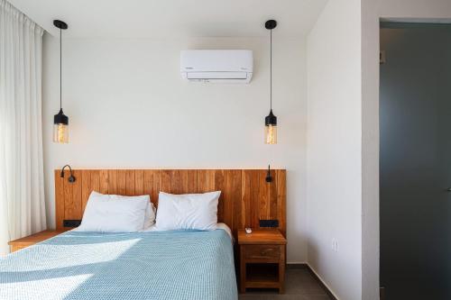 a bedroom with a bed with a wooden headboard and lights at Villa Oniriko in Marioú