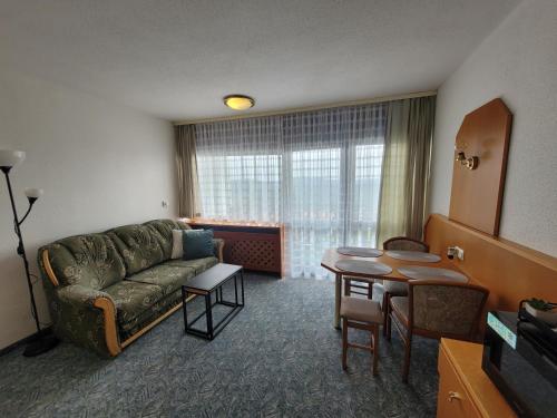 a living room with a couch and a table at Mitterdorf - apartmán Almberg in Mitterfirmiansreut