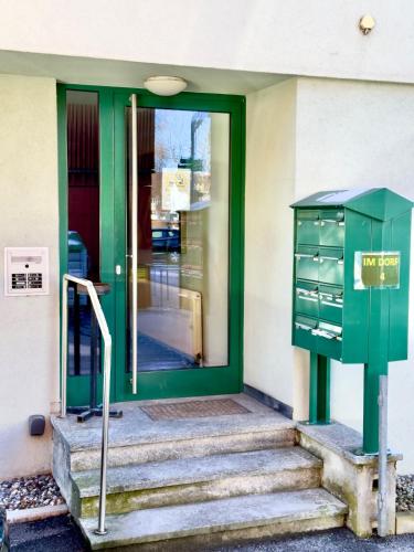 a green door of a building with a green cabinet at Boutique Appartement mit Balkon in Lauterach