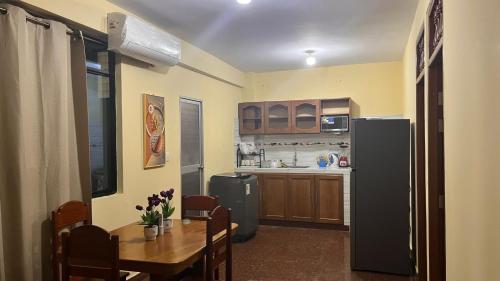 a kitchen and dining room with a table and a refrigerator at MESAN Tranquilidad y Comfort in Yurimaguas