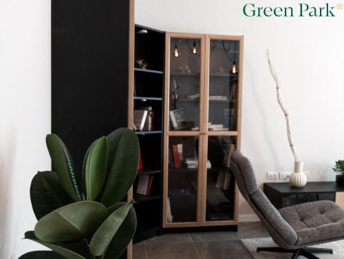 a living room with a green plant and a chair at Green Park Rooms in San Donato Milanese