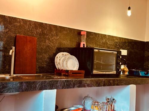 a kitchen counter with a microwave and a plate on it at Coco Cabana Hikkaduwa in Hikkaduwa
