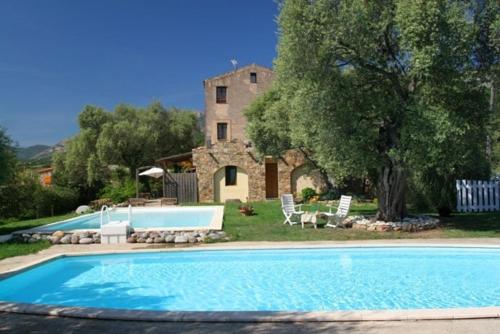 une grande piscine devant une maison dans l'établissement 1st floor apartment in 18th century character house, à Calvi