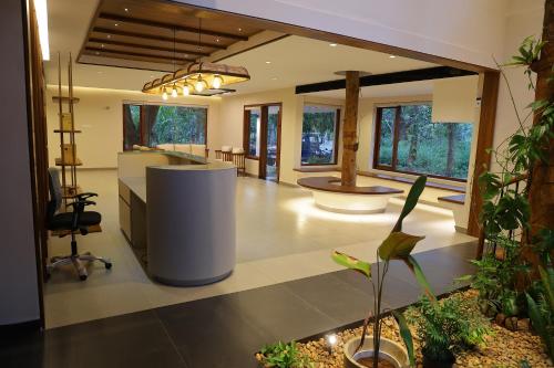 a large room with a kitchen and a living room at Hortus Malabaricus Garden Resort in Cheruthuruthi
