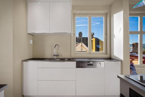 a kitchen with white cabinets and a window at The Townhouse Dream I Must See Views! in Bergen