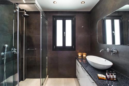 La salle de bains est pourvue d'un lavabo et d'une douche. dans l'établissement Elea Casa, à Oia