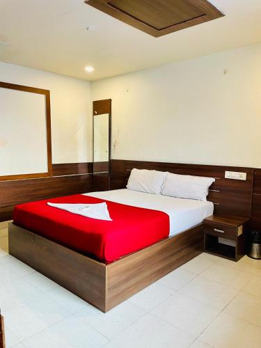 a bedroom with a large bed with a red blanket at Meridin Regency in Ernakulam