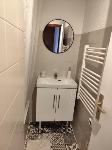 une salle de bain avec un lavabo blanc et un miroir dans l'établissement Milky Way - Appartement en bas des pistes du Mourtis, à Boutx