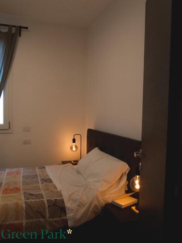 a bedroom with a bed and two lights on a table at Green Park Rooms in San Donato Milanese