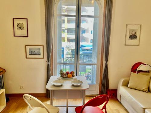 un salon avec une table et une fenêtre dans l'établissement Palais Monty YourHostHelper, à Nice