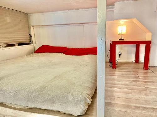 Cette chambre comprend un grand lit et une table rouge. dans l'établissement Palais Monty YourHostHelper, à Nice