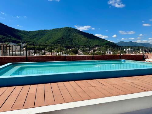 een zwembad op een terras met bergen op de achtergrond bij C2 Apart Salta in Salta