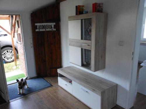 un chien debout dans un salon avec un banc dans l'établissement Freistehendes Friesenhaus Heimathafen, à Halbemond