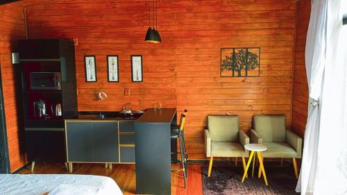 a kitchen with two chairs and a sink in a room at Pousada Recanto entre Rios CHALE SOL POENTE in Urubici