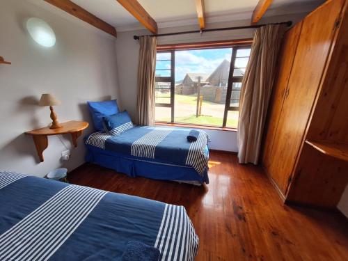 due letti in una stanza con una grande finestra di PA Sands Beach House Kowie River 9 Sleeper Pool a Port Alfred