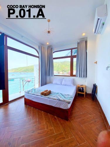 a bedroom with a bed and a large window at Coco Bay Hon Son in Lai Sơn