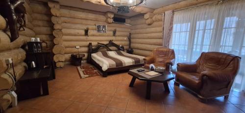 a living room with a bed and a chair and a table at Фільварок Кмитів in Kosharishche