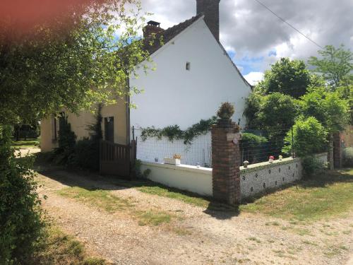 a white house with a fence in front of it at Les Lodges de Phanou in Prissac