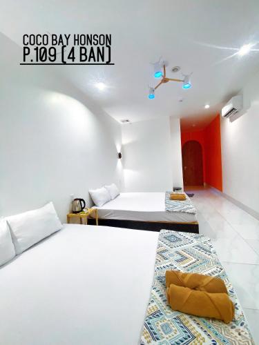 a hotel room with two beds and a sign that says gogo bay honeymoon at Coco Bay Hon Son in Lai Sơn