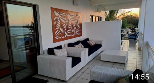 a living room with two chairs and a painting on the wall at Casa Do Mar Guest House in Praia do Tofo
