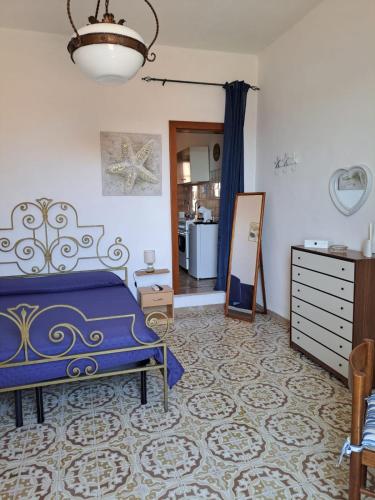 a bedroom with a blue bed and a mirror at Casa Nenetta in La Maddalena