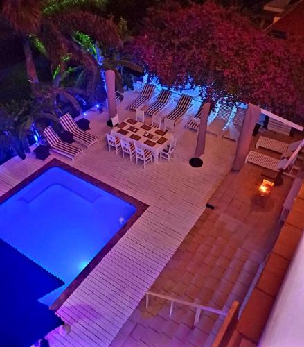 a patio with a table and chairs and a swimming pool at Casa Do Mar Guest House in Praia do Tofo