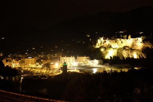 une ville la nuit avec un château en arrière-plan dans l'établissement Villa Talabar, à Cassis