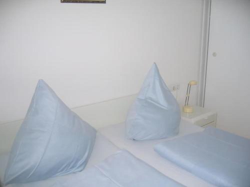 a white bed with two pillows on top of it at Ferienwohnungen Alte Schmiede 9 in Norderney