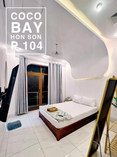 a bedroom with a bed and a sign that reads coo bay than son r at Coco Bay Hon Son in Lai Sơn
