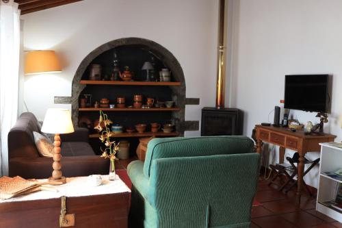 a living room with a couch and a chair at Nanna's Country Home in Feteira Grande