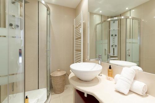 une salle de bain avec un lavabo et une douche en verre dans l'établissement Immogroom - Spacious bright T3 - Sea view -Terrace, à Cannes
