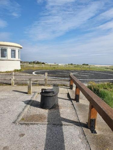 a bench with a bucket on it next to a fence at Gite Baie de Somme in Cayeux-sur-Mer