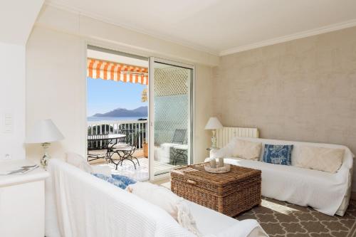 un salon avec un canapé et une table dans l'établissement Immogroom - Spacious bright T3 - Sea view -Terrace, à Cannes