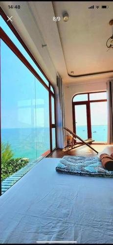 a bedroom with a bed with a view of the ocean at Coco Bay Hon Son in Lai Sơn