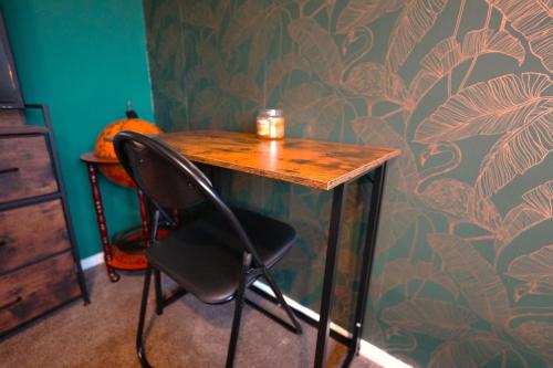 レイランドにあるDetached Homestay - Super, King & Double Rooms - Leyland, Preston, Chorley, Lancashireの椅子と壁に掛けられたカボチャのある机