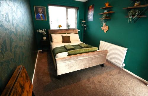 a bedroom with a bed in a green wall at Detached Homestay - Super, King & Double Rooms - Leyland, Preston, Chorley, Lancashire in Leyland