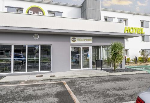 a hotel with a parking lot in front of it at B&B HOTEL Bordeaux Le Haillan 3 étoiles in Le Haillan