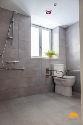 a bathroom with a toilet and a shower with a window at Villalobos by Cadiz Time in Cádiz