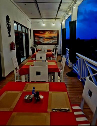 a restaurant with tables and chairs and a large screen at Casa Do Mar Guest House in Praia do Tofo